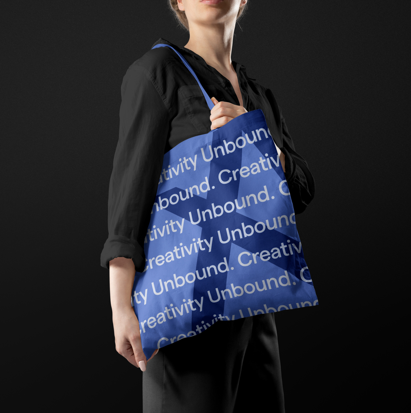 A mockup of a woman holding a branded tote bag with Apiero Design's logo and the words Creativity Unbound repeated across the bag.