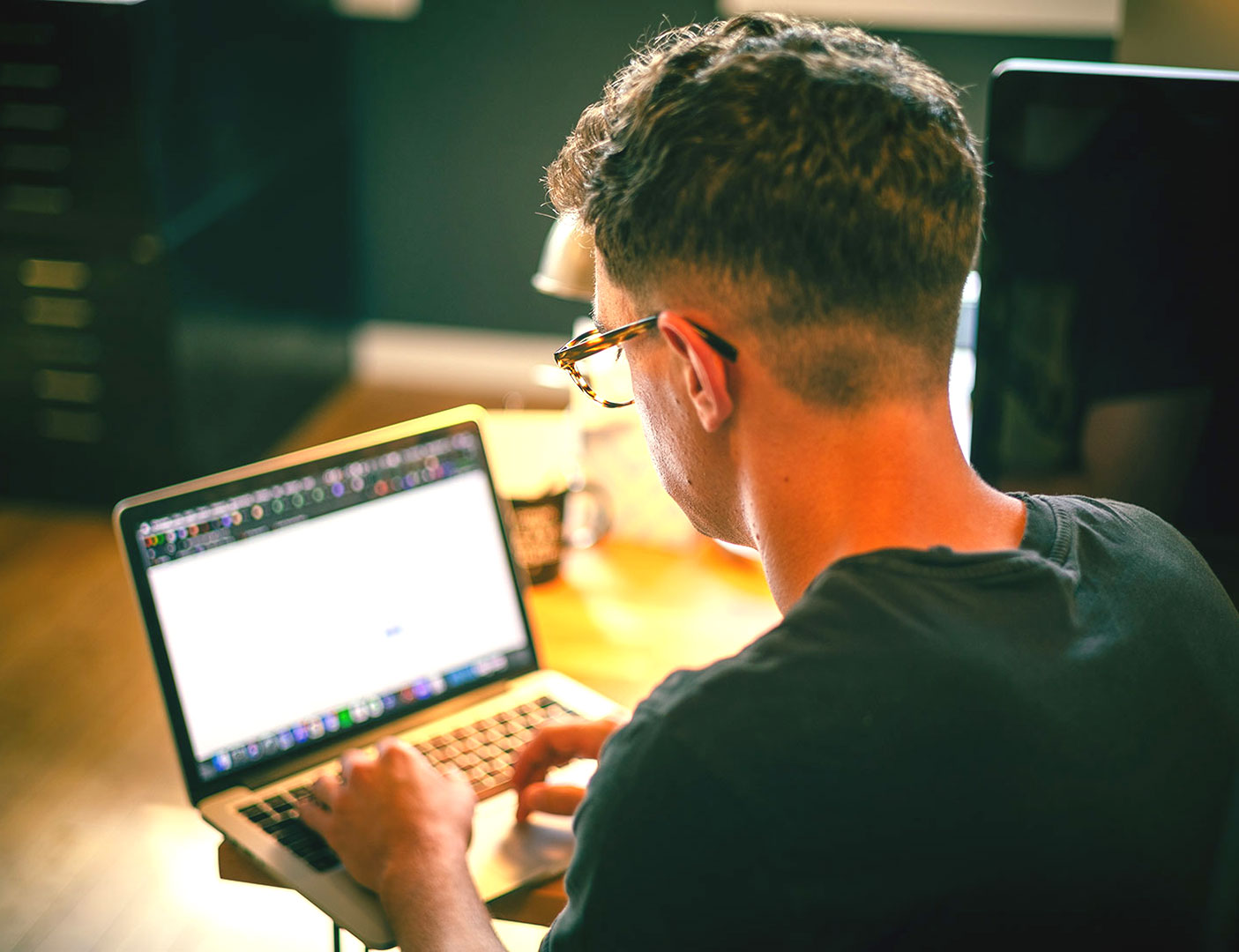 Over the shoulder of a website designer working on a laptop for an AEC website.