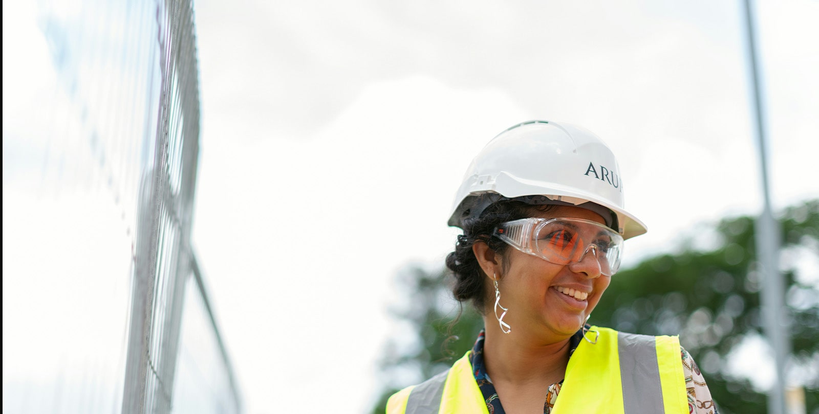 Conti Federal contractor smiling in a safety vest, safety glasses, and hard hat.