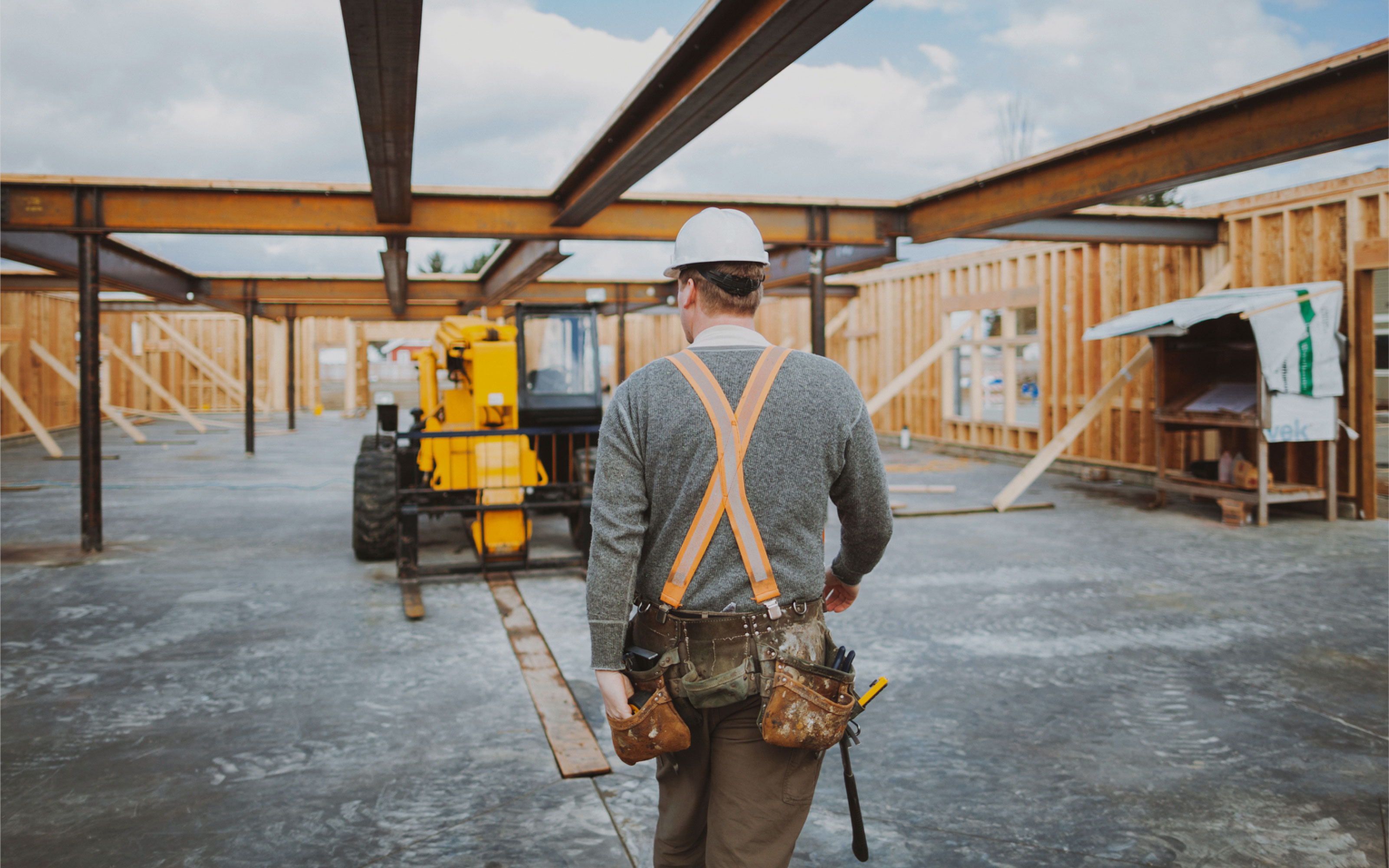 JJ White contractor walking towards a forklift for construction website design page.