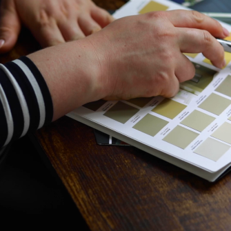 A person reviewing a paint color chart.